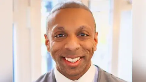 Martyn Latchman, 38, a former teacher and father of two, died in July 2025 after suffering a cardiac arrest during the preparatory phase of a hair transplant at the Dr Cinik Hair Transplant Center in Istanbul. A coroner later linked his death to a rare complication from local anaesthetic. Credit: Martyn Latchman / LinkedIn via BBC